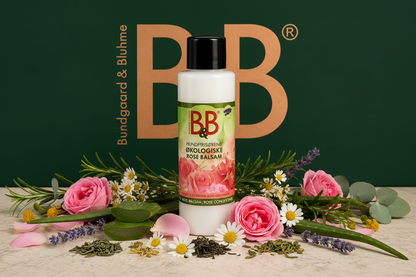 B&B Organic Rose Balm surrounded by fresh roses and botanical ingredients