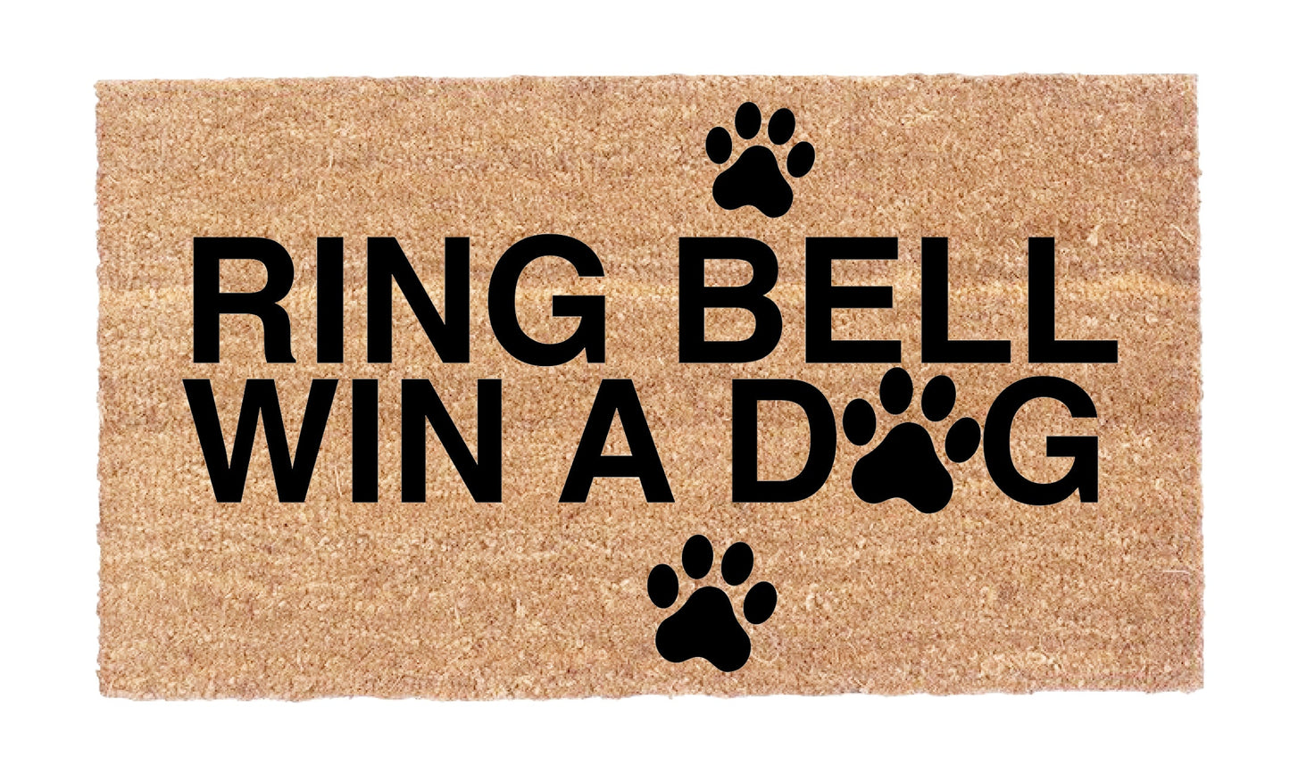 Close-up of Ring Bell Win a Dog coir doormat showing black lettering and paw print details